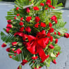 Large red rose and carnation standing spray with a red bow