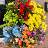 Large standing spray of multicolored flowers with red roses and yellow daisies
