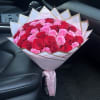 Large bouquet of pink and red roses wrapped in white paper