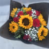 Bouquet of sunflowers and red roses wrapped in black paper