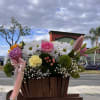 A bright and cheerful mix of sunflowers, roses, and delicate blooms, made