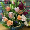 Mixed bouquet with roses, tulips, and lilies in a ceramic bowl