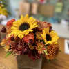 Autumn bouquet of sunflowers and chrysanthemums in a square vase