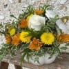 White rose and yellow-orange flowers in a white pumpkin container