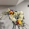 Large floral heart on an easel with white hydrangeas and colorful roses
