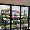 Flower shop display case filled with colorful bouquets and vase arrangements