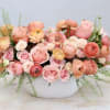 Pink and peach ranunculus bouquet in a white textured vase