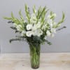 White gladiolus and lisianthus in a clear glass vase