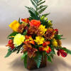 Mixed bouquet of yellow, orange, and red flowers in a brown vase