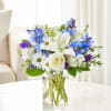 White and blue mixed bouquet in a clear glass vase
