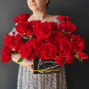 Large bouquet of red roses in a black box with a gold band
