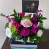 Pink and white roses with magenta blooms in a white box arrangement