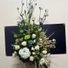 Tall floral arrangement with white roses and lilies in a vase