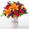 Bouquet of orange lilies and pink roses in a birthday vase