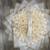 Large bouquet of cream roses wrapped in white paper with a ribbon