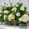 White roses and hydrangeas arranged in a low black container
