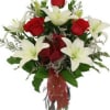Bouquet of red roses and white lilies in a clear vase