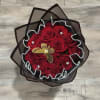 Bouquet of red roses wrapped in black paper with pearl trim