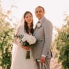 Bride and groom holding a white bridal bouquet outdoors