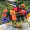 Colorful mixed bouquet in a gold vase with roses and dahlias