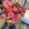 Bright mixed bouquet with pink anthuriums, roses, and protea
