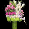 Pink roses and white orchids arranged in a tall glass vase
