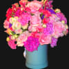 Large bouquet of pink and purple flowers in a blue hatbox