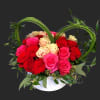 Heart-shaped rose arrangement in a white container