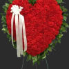 Heart-shaped red floral wreath with a white ribbon bow