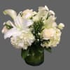 White lilies and roses arranged in a glass vase