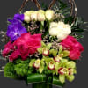 Colorful floral arrangement in a glass vase with roses and orchids