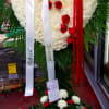 Heart-shaped floral tribute with red and white flowers and long ribbons