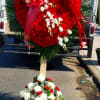 Large red heart-shaped floral tribute with white accents on a stand