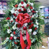 Large standing floral spray with red roses and white flowers, accented by a red bow