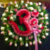 Large floral wreath with pink and white roses and a pink ribbon bow