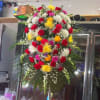 Large standing floral spray with red, white, yellow, and pink flowers