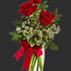 Red roses in a clear glass vase with a red ribbon
