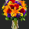 Bouquet of red roses, orange lilies, and yellow daisies in a clear vase