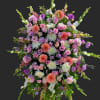 Large standing spray of pink, purple, and white flowers on an easel