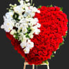 Heart-shaped arrangement of red roses with white orchids