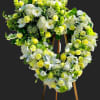 Heart-shaped floral wreath of white and yellow flowers on an easel