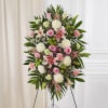 Standing floral spray with pink lilies, roses, and white mums on an easel