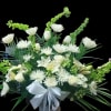 White floral arrangement with lilies, roses, and a white ribbon