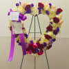 Heart-shaped floral wreath on a stand with roses and chrysanthemums