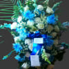 Tall blue and white floral standing spray on an easel with ribbon