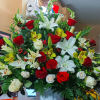 Large mixed bouquet of red and white flowers in a white vase