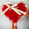 Heart-shaped box filled with red roses and tied with a white ribbon