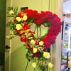 Heart-shaped floral standing arrangement with red carnations and yellow roses