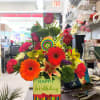 Colorful birthday flower arrangement with gerbera daisies and roses in a gift box