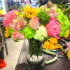 Bright mixed bouquet in a glass vase with pink, yellow, and green flowers